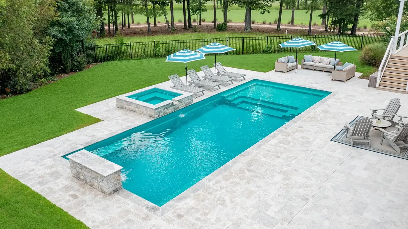 Completed fiberglass pool and spa with travertine deck and lounge seating