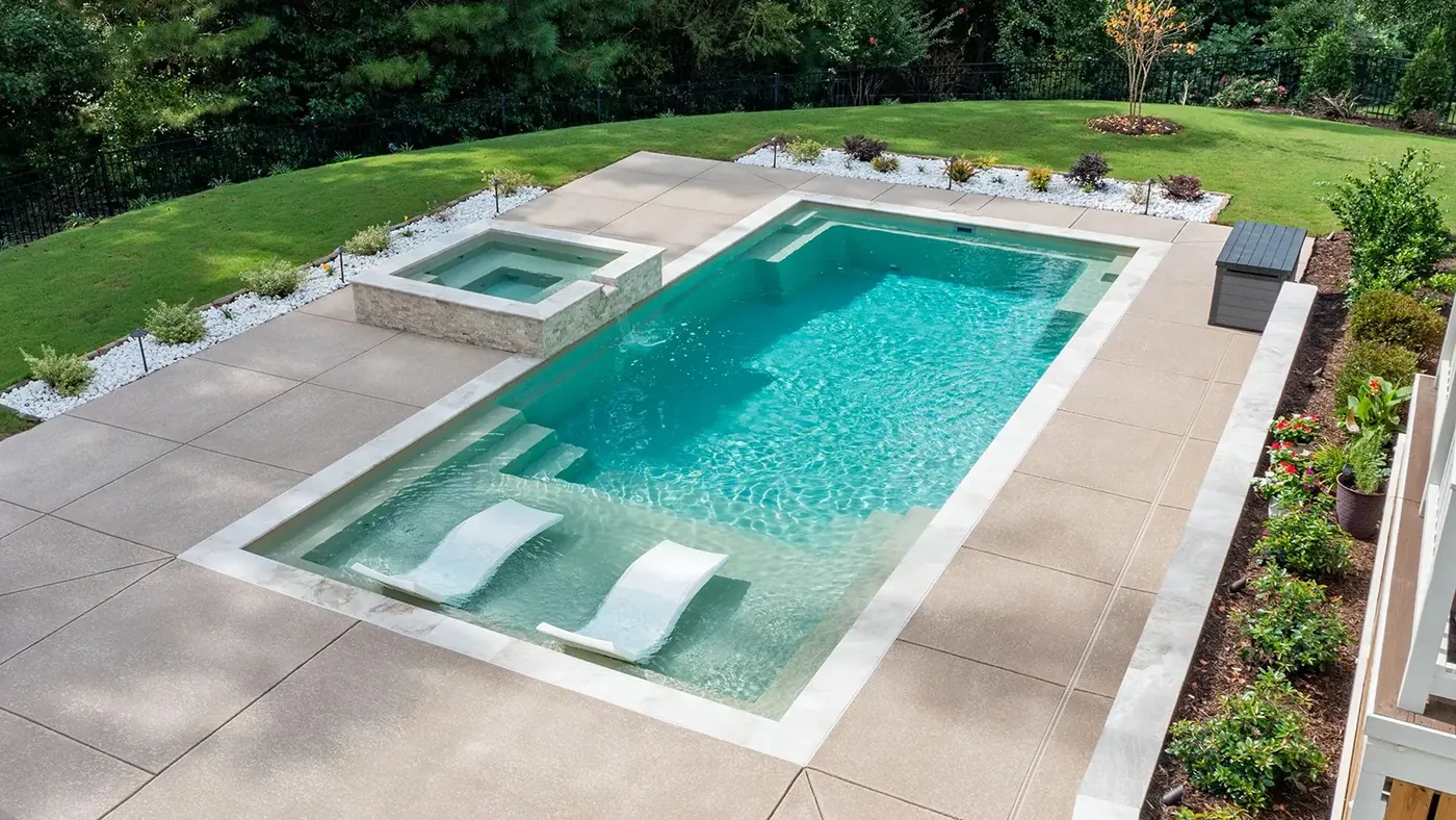 Fiberglass pool and spa with water feature and loungers