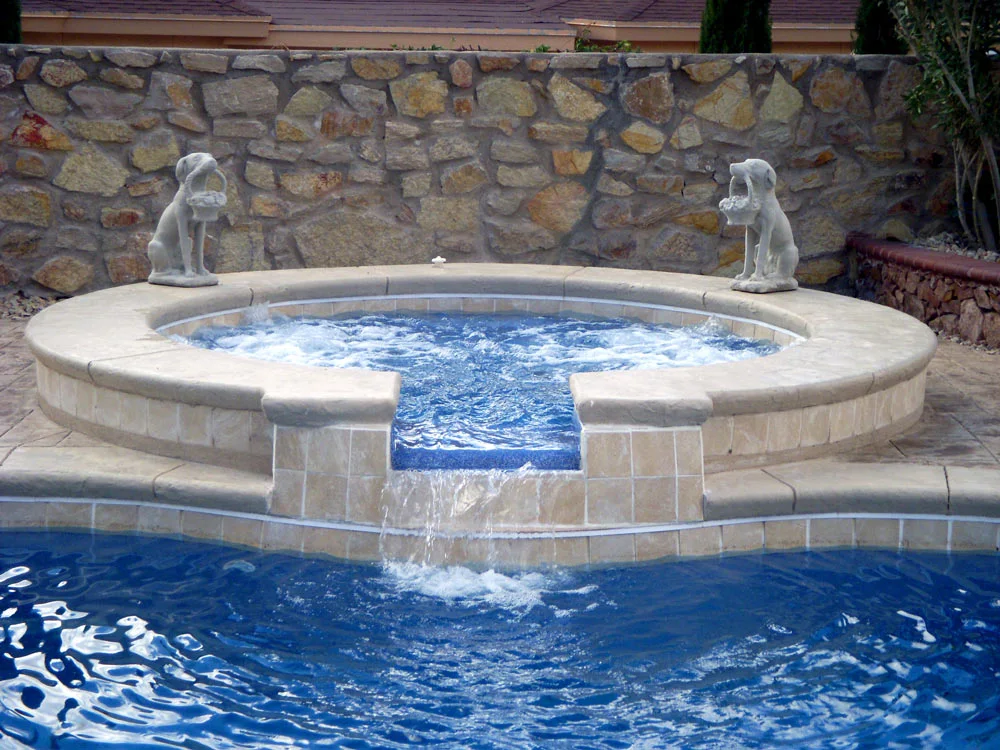 Raised stone spillover spa flowing into the pool below
